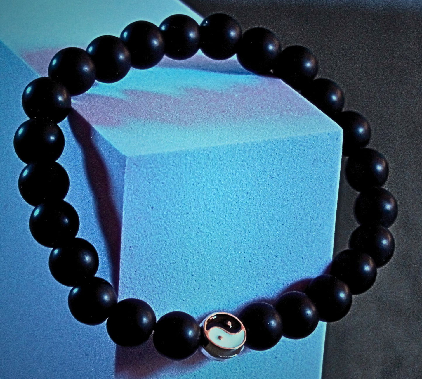 Glossy onyx-style bracelet with yin-yang charm, balanced in light and dark tones for a modern spiritual edge – Onyx Shift by Charmed Curations.