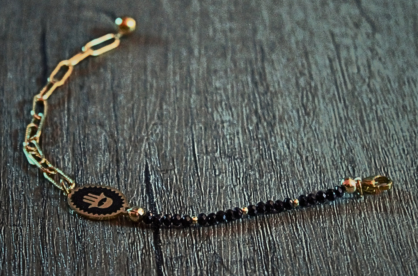 Lobster clasp with gold-tone chain and faceted black beads on a minimalist bracelet