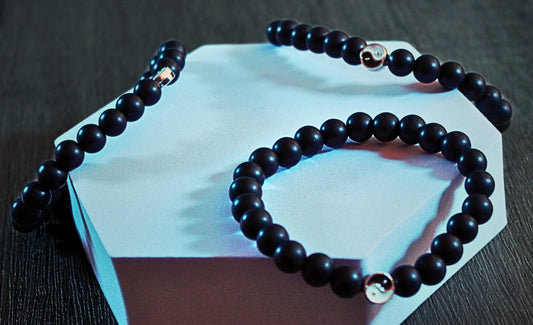 Black bead bracelet with central silver bar