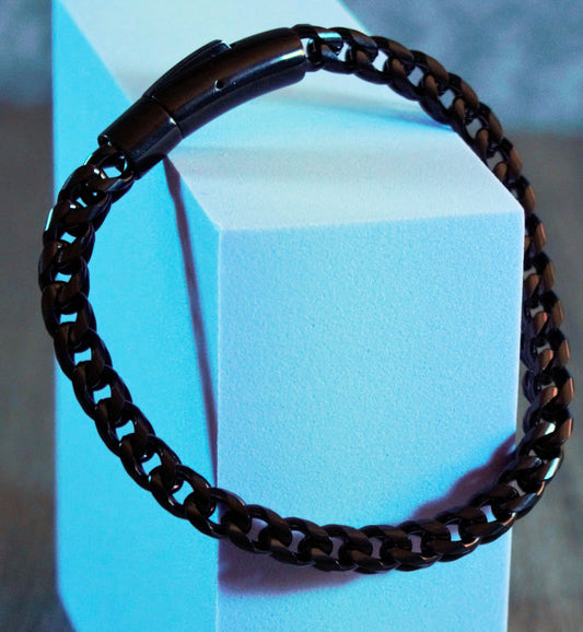 Gunmetal chain and charcoal beaded bracelet with industrial edge, styled in deep shadows – Shadow Link by Charmed Curations.